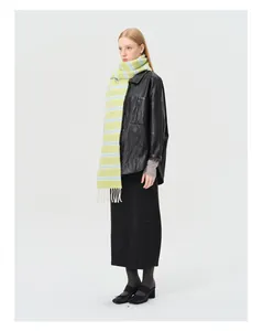 Détail d'une écharpe rayée en mélange de laine vert et bleu avec des franges blanches
