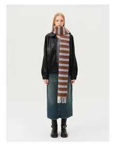 Détail d'écharpe en laine rayée montrant la texture en maille et de longues franges crème