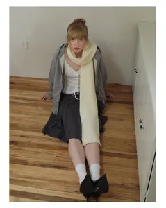 Detailed knit texture of cream-colored wool blend scarf for winter warmth and style