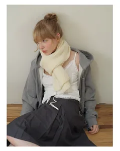 Detail of soft off-white chunky knit wool blend scarf paired with a grey zip-up hoodie
