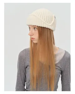 Detail of cream rib-knit aviator beanie showing thick wool blend texture and cuffed edge