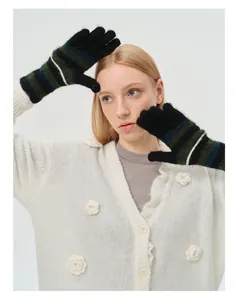 Detailed knit texture of black gloves with forest green and navy blue stripes