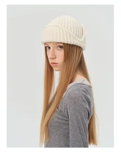 Detailed texture of off-white wool blend knit beanie with thick vertical ribbed pattern