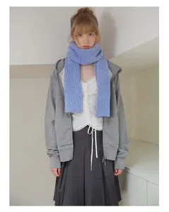 Close-up of a soft light blue wool blend knitted scarf styled in a trendy Korean look
