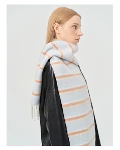 Détail d'une écharpe en laine mélangée à rayures avec des bords à franges doux