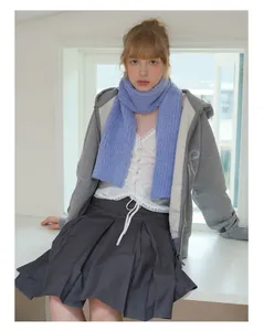 Detailed view of long purple wool blend scarf styled with a grey hoodie and pleated skirt