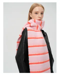 Détail d'une écharpe rayée rose et orange en laine avec texture à franges