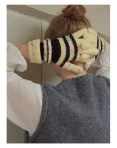 Details von gestreiften Mohair-Strickhandschuhen mit gelben und schwarzen Mustern