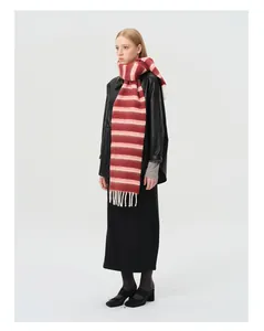 Détail d'une écharpe rayée en laine avec franges colorées sur un manteau en cuir noir
