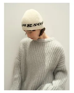 Detailaufnahme der Wollstrickmütze mit Buchstaben-Jacquard und weichem Rippstrickpullover