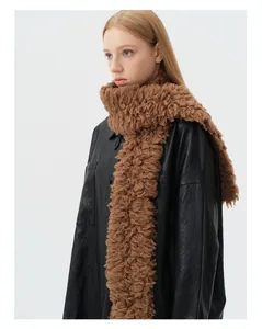 Close-up of deep brown 100% wool knit scarf with soft lamb hair texture on model