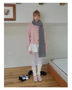 Detail of pink knit cardigan and thick grey wool blend scarf in a cozy Korean style outfit