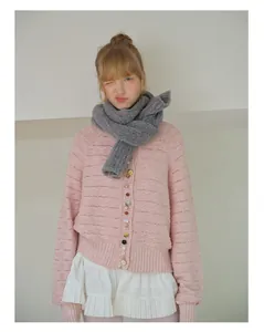 Detail of pink knitted hollow cardigan with vintage decorative buttons and wool scarf