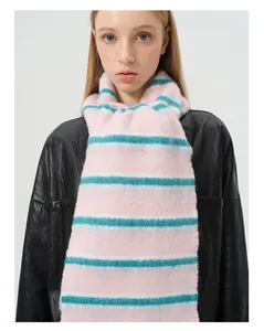 Vue détaillée d'une écharpe en laine rayée rose et turquoise avec des franges douces