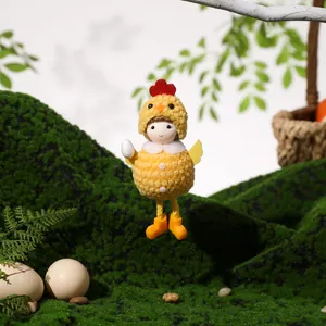 Easter chick plush pendant with egg on green moss background for festive decoration