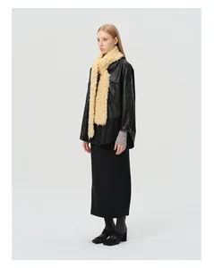 Full view of women's black outfit styled with a long cream wool shearling textured scarf