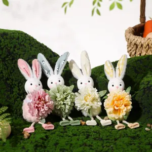 Set of four plush Easter bunny ornaments with colorful flowers on mossy background