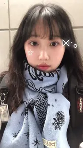 Detail of light blue knit scarf with star and snowflake patterns on a young woman