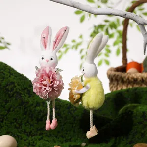Detail of plush Easter bunny hanging ornaments with floral accents in a spring scene