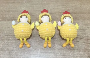 Detailed view of three yellow plush chick ornaments with colorful Easter eggs and hanging strings