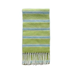 Écharpe en laine mélangée à rayures vertes et bleues avec pompons sur fond blanc