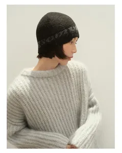 Nahaufnahme der nahtlosen dunkelgrauen Wollstrickmütze mit weißem Jacquard-Schriftzug