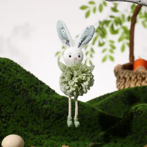 Easter bunny plush hanging decoration with green flower and long legs in a forest setting