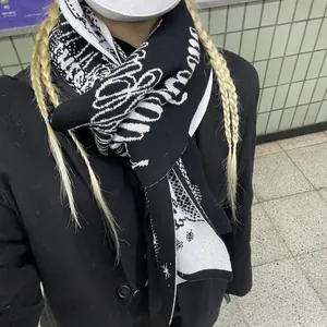 Winter knitted scarf featuring black and white jacquard letters and snowflake patterns