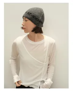 Detail einer dunkelgrauen Strickmütze aus Wollmischung mit Jacquardmuster und Langarmshirt