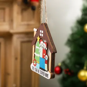 Holzhaus-Weihnachtsschmuck mit Maskenfamilie und Aufschrift 'The Year We Stayed Home'