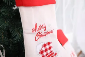 Close-up of Merry Christmas embroidery and red plaid patterns on the burlap stocking