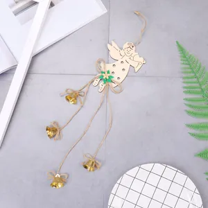 Wooden Christmas angel pendant with golden metal bells and green felt flower on rustic ground