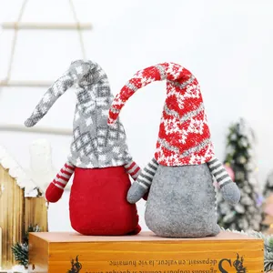 Pair of Scandinavian Christmas gnomes with long hats sitting on a vintage wooden box