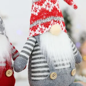 Handcrafted Christmas gnomes with knitted hats and white beards on a festive background