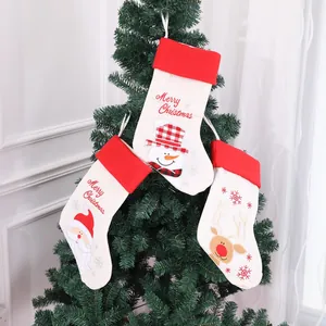 Set of three 20-inch burlap embroidered Christmas stockings hanging on a tree