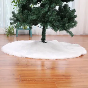 Detail of soft white faux fur Christmas tree skirt on wooden floor in cozy home setting