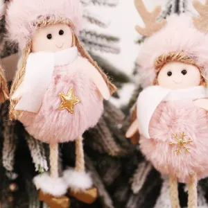Pink plush Christmas dolls with gold star accents hanging on a decorated tree