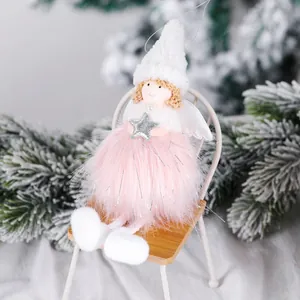 Ange de Noël en peluche avec robe rose et ailes assis sur une mini chaise en bois décorative