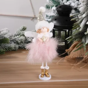 Detail of Christmas angel tree topper with pink feather skirt and golden glitter accents