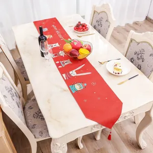 Red Christmas table runner with cartoon animal prints and tassels on marble table