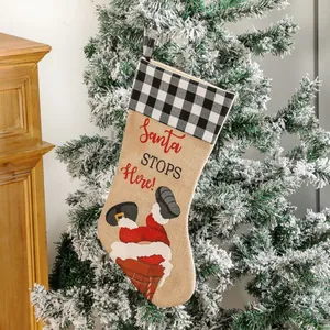 Beige linen Christmas stocking featuring a buffalo plaid cuff and Santa chimney illustration
