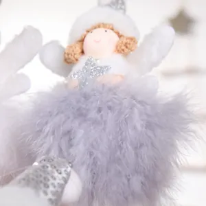 Detail of plush angel Christmas tree ornament with white feather wings and silver star