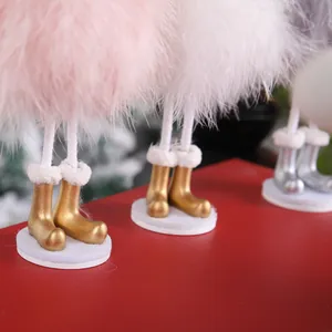 Detailed view of handmade Christmas plush doll with pink feathers and gold glittery boots