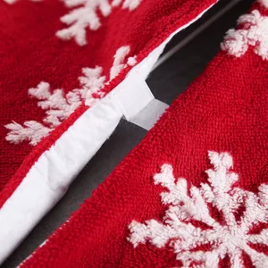 Red plush Christmas tree skirt with white snowflake patterns and Velcro closure
