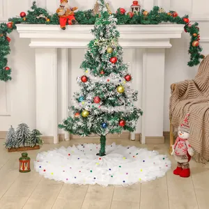 White tulle tiered Christmas tree skirt with colorful pom-poms and flocked tree decoration