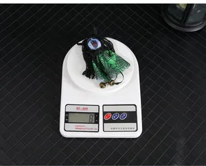 Detailed view of an 8g Halloween ghost doll pendant with green spiderweb pattern skirt