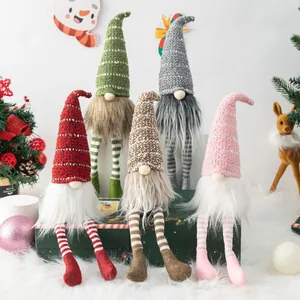 Set of five colorful Christmas gnomes with striped legs on a festive green gift box