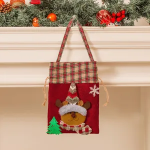 Sac cadeau de Noël rouge avec broderie d'élan en peluche et bordure à carreaux sur cheminée