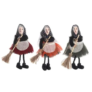 Drie Halloween heksenpoppen met bezems en schorten in de kleuren rood, oranje en groen