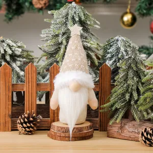 Christmas gnome plush ornament with golden star on knitted hat in a winter forest scene